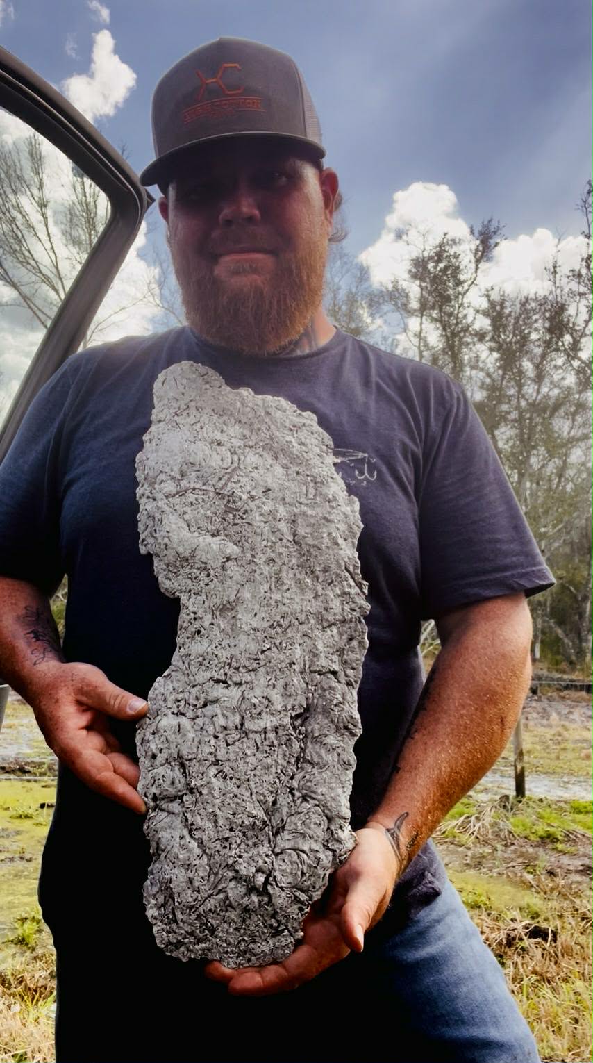 Jesse Johnson holding a footprint cast in the field